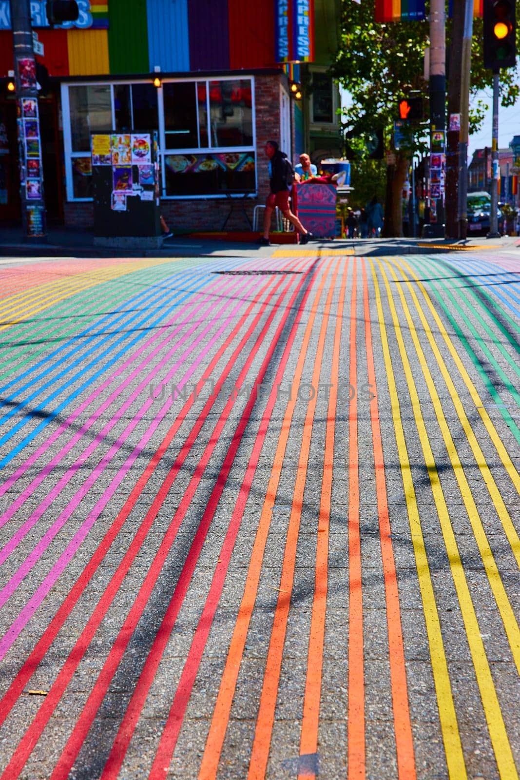 Image of Rainbow crosswalk on bright sunny day leading to Gyro Xpress storefront