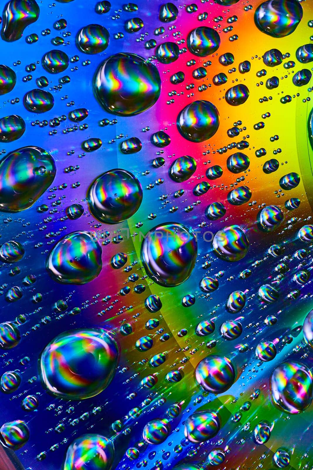 Image of Dark swirling water drops in cosmic rainbow Saturn ring in psychedelic background asset