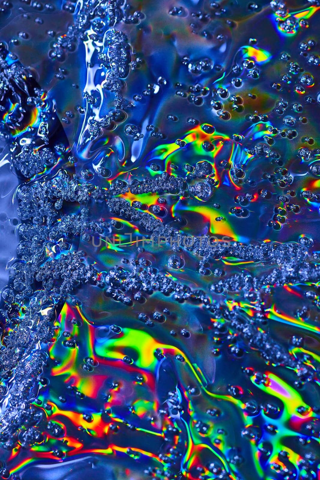 Image of Oily surface with rainbow burst of color and streams of bubbles in abstract background asset