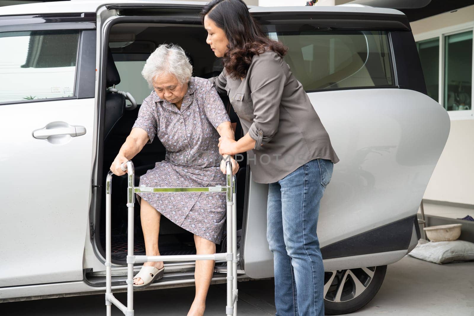Asian senior woman patient walk with walker prepare get to her car, healthy strong medical concept.