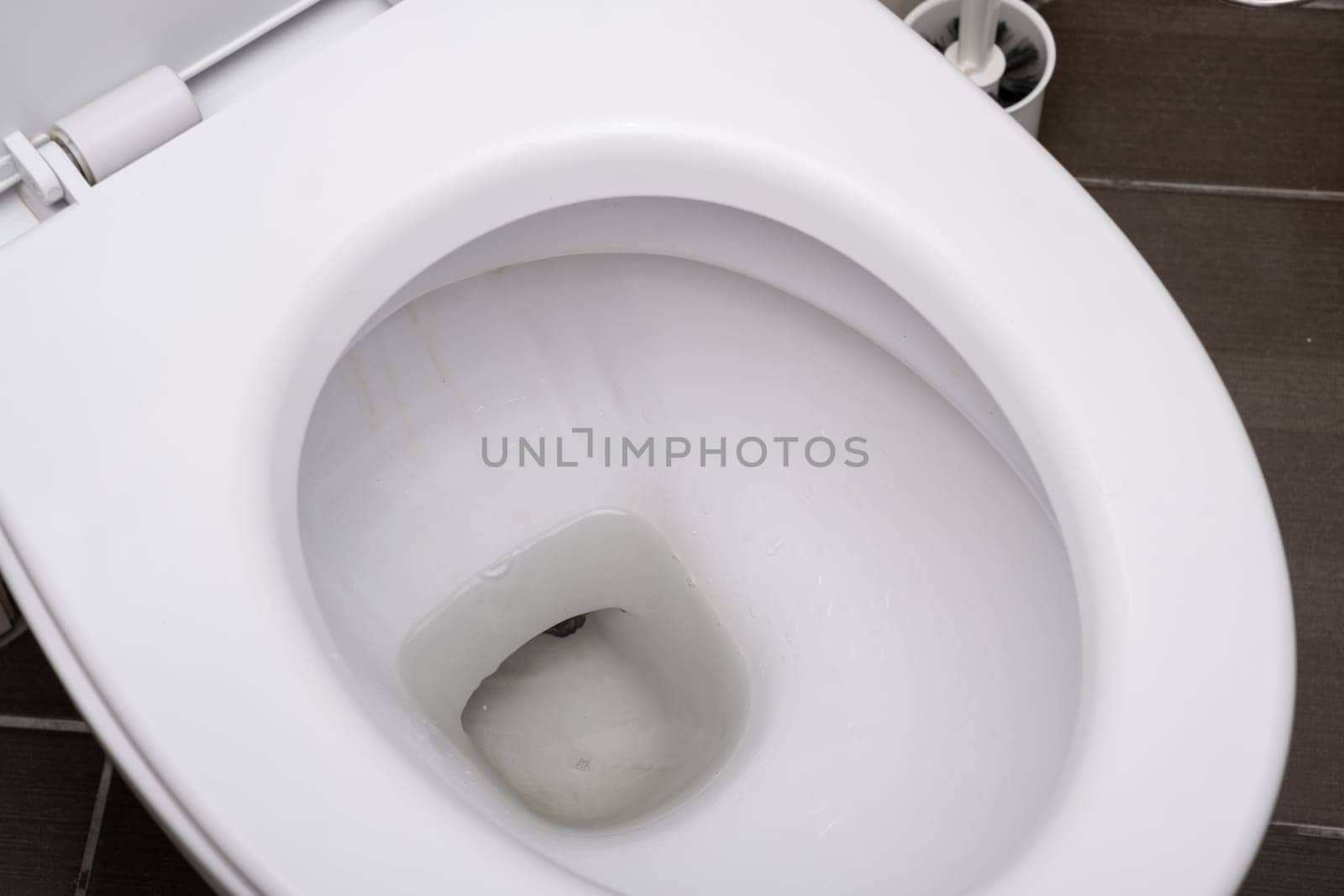 White toilet bowl in the toilet in the bathroom. by AnatoliiFoto