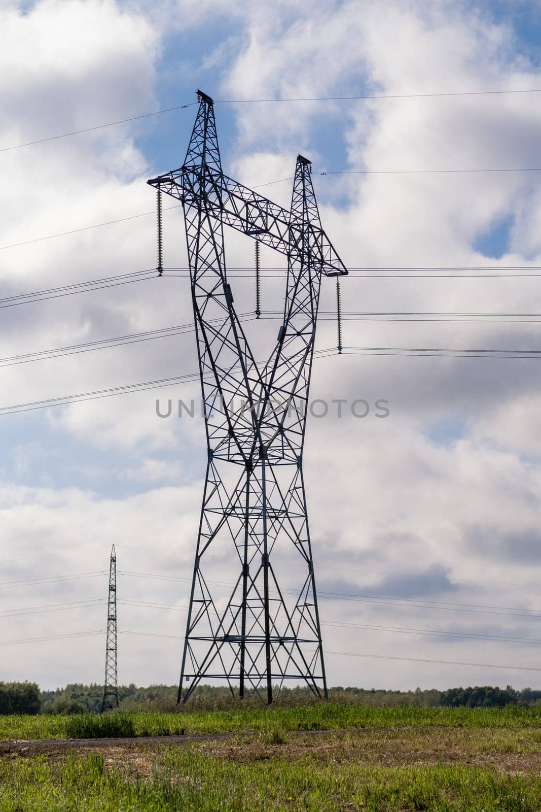 Metal poles electric supports for high-voltage wires in the fields in the summer.High Voltage Poles or Electric tower is transmission high voltage power locate on green field Energy technology concept