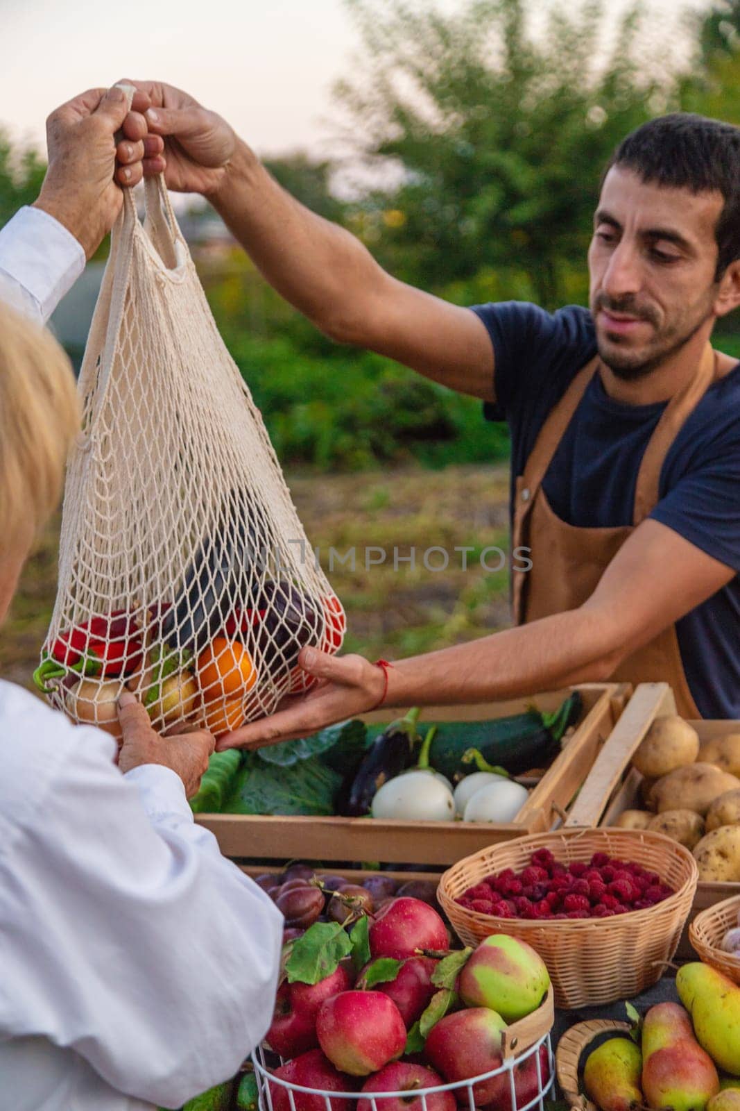 The farmer sells fruits and vegetables at the farmers market. Selective focus. by yanadjana