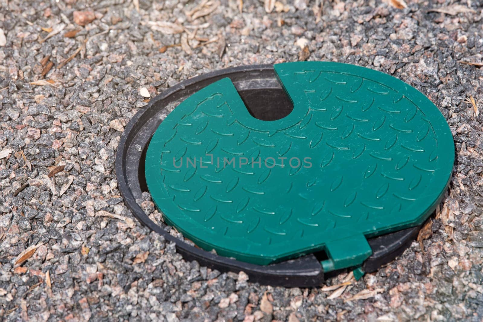 A plastic hatch in the garden covering the connection point for the irrigation hose. A protective hatch in the garden for connecting water and watering plants. by SERSOL