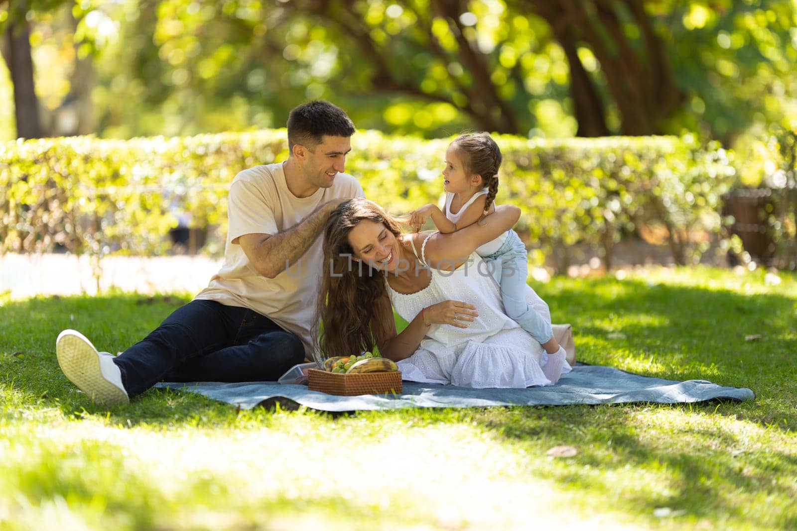 Young family having a picnic and having fun in the park. Mid shot