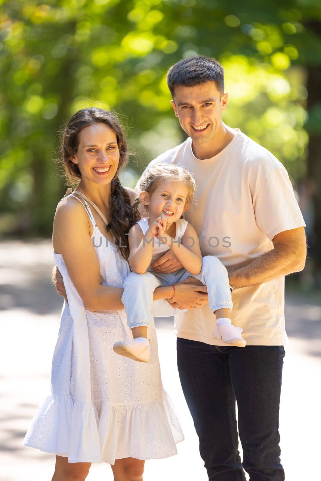 Smiling happy family in the park. Vertical shot