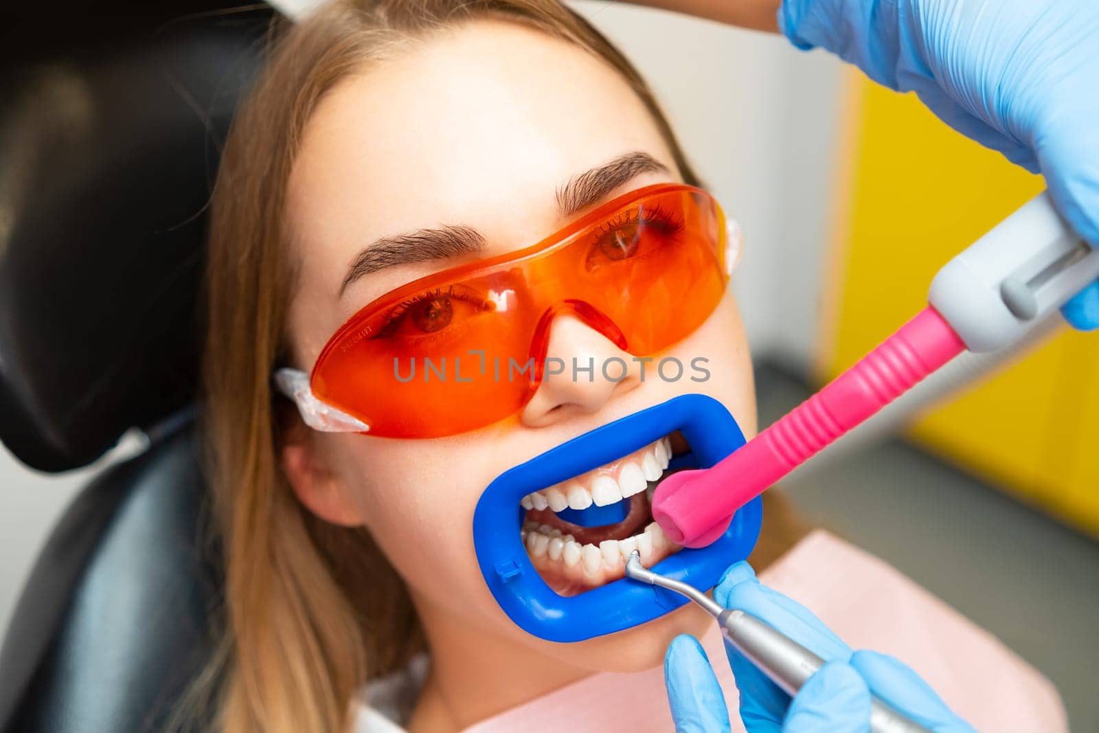 Close up a patient while doing a professional teeth cleaning procedure at the clinic. by vladimka