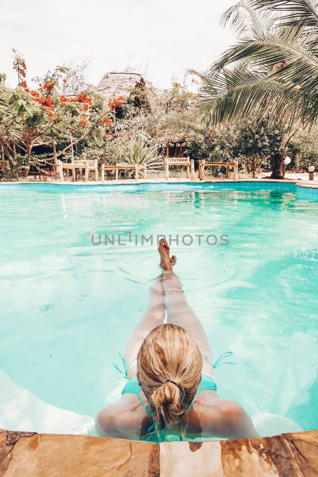 Caucasian lady floating in swimming pool. by kasto
