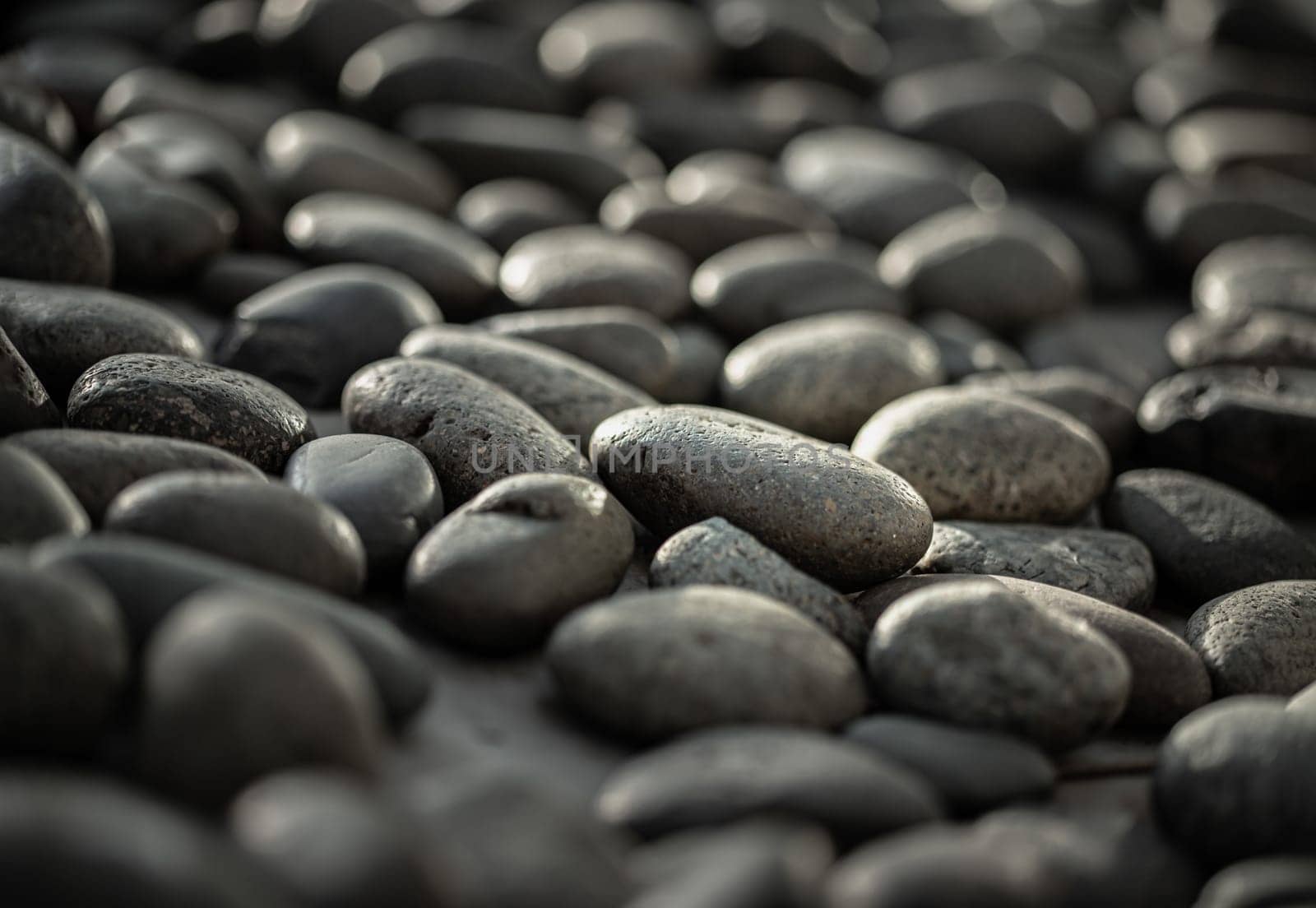 Close-up view of Black pebbles. Detail stone cobblestone as a background, Copy space, Selective focus.
