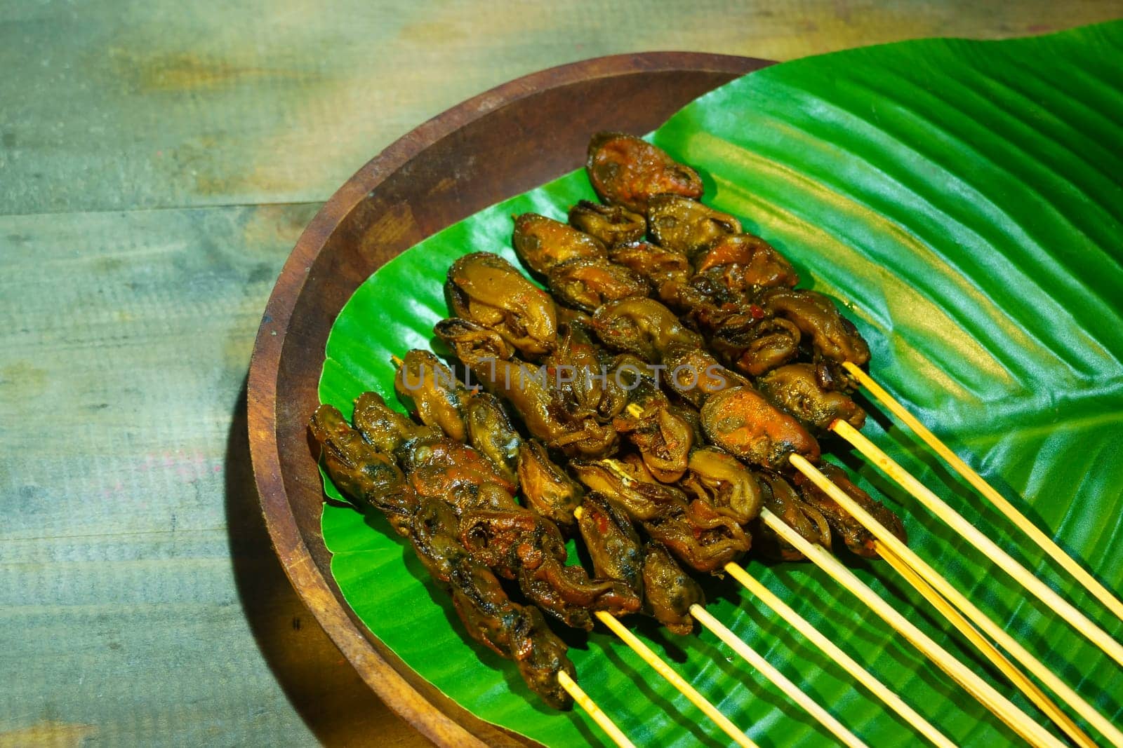 Satay Kerang Surabaya is a delicious Indonesian street food consisting of grilled clams on skewers, marinated in a savory sauce. The clams are often served with a spicy sambal.
