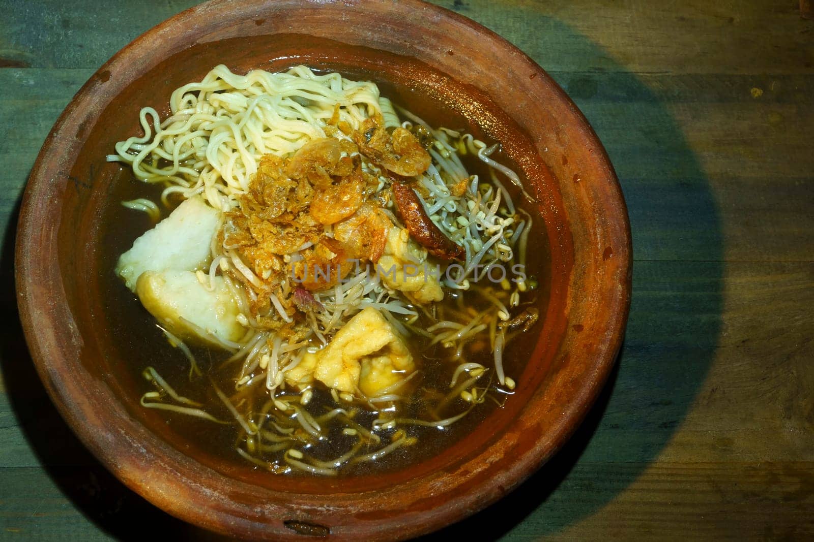 A bowl of Lontong Mie, a popular Indonesian soup made with rice cake, noodles, and various toppings.