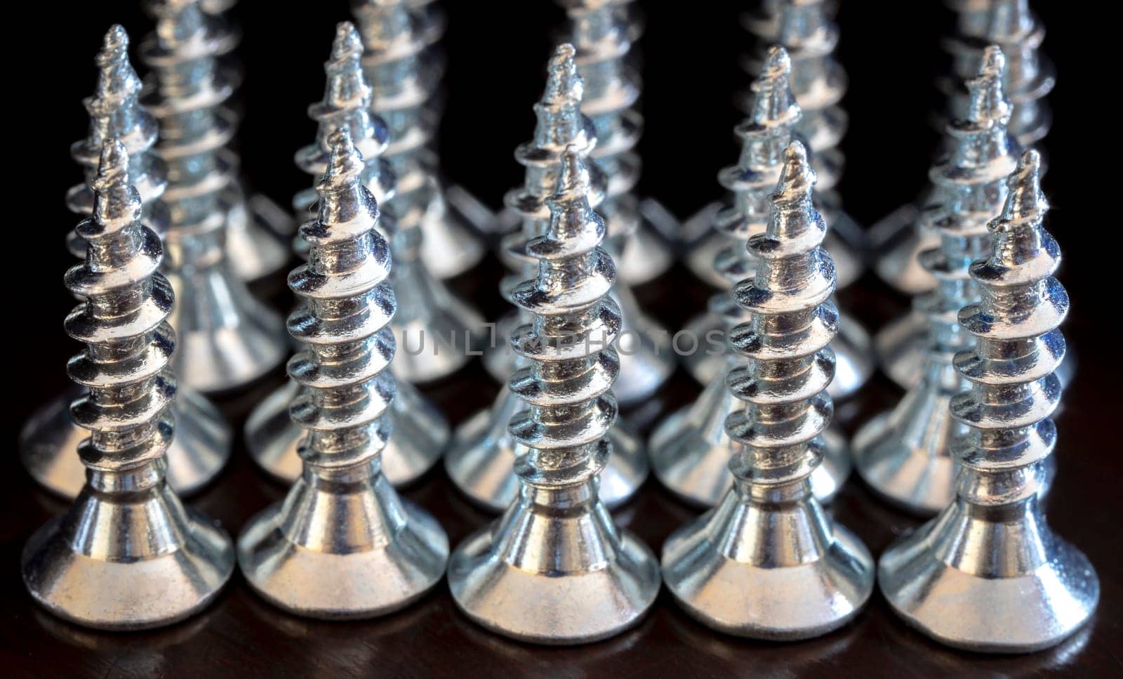 Close up of screws on a black background. Advertising photo