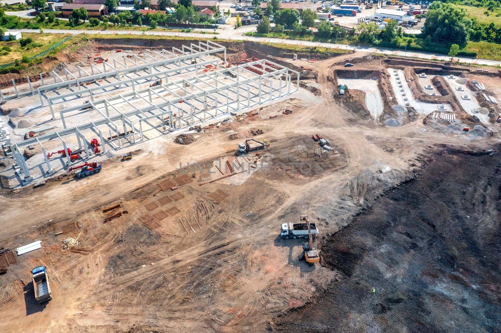 Aerial top view of huge construction site with many working heavy machines