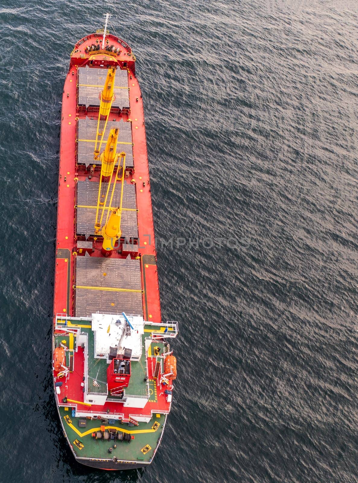 Aerial view of a container cargo ship on the sea. Cargo and shipping logistics business. Vertical view