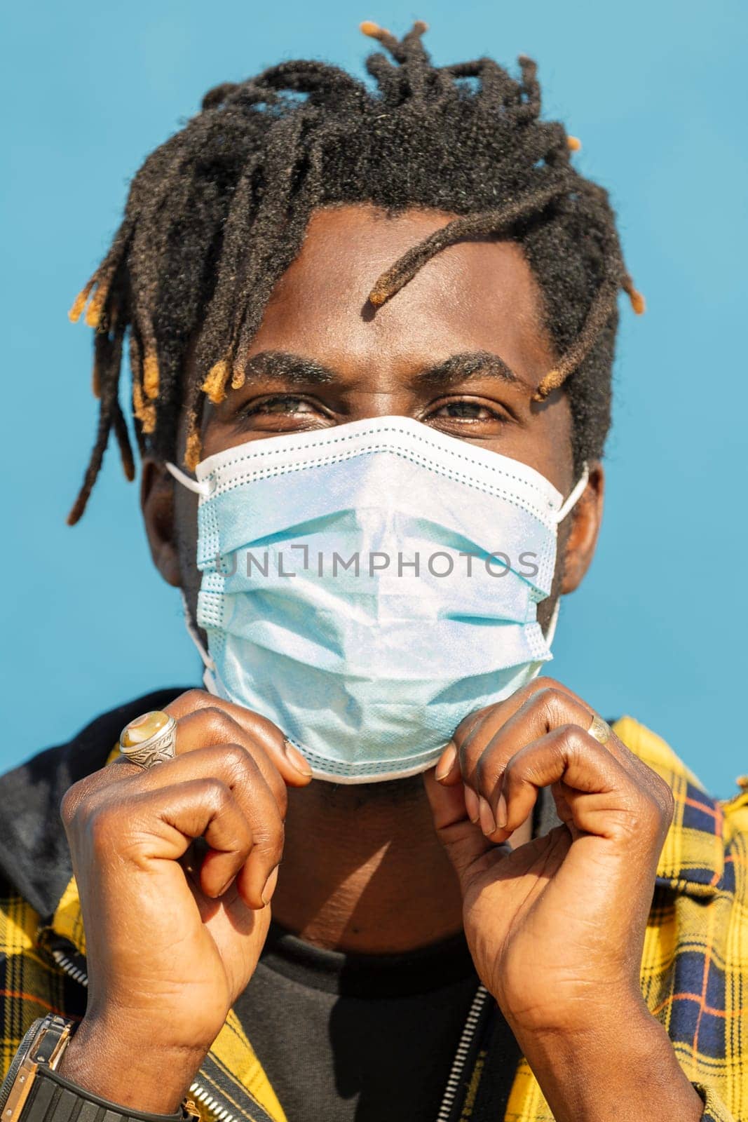 vertical closeup of an attractive young black man wearing a protective mask, lifestyle concept and virus protection