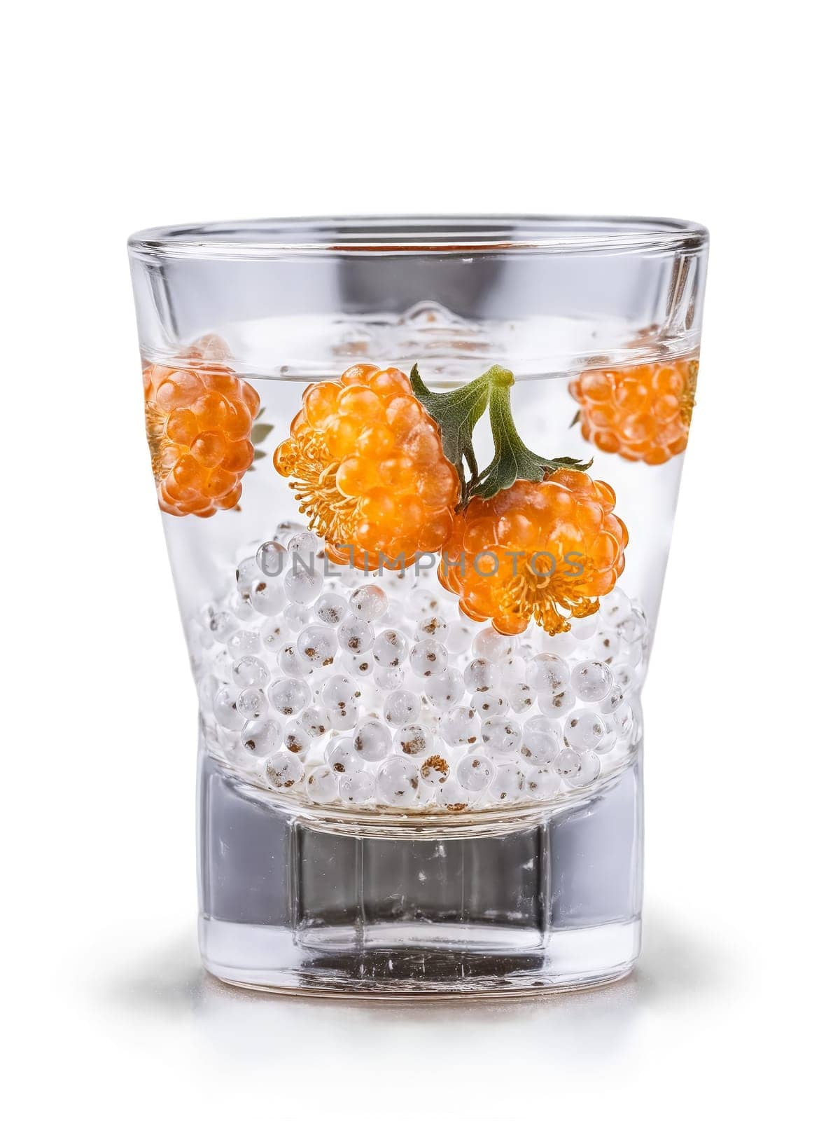 Finnish Cloudberry Liqueur in shot glass garnished with few fresh cloudberries. Drink isolated on transparent background.