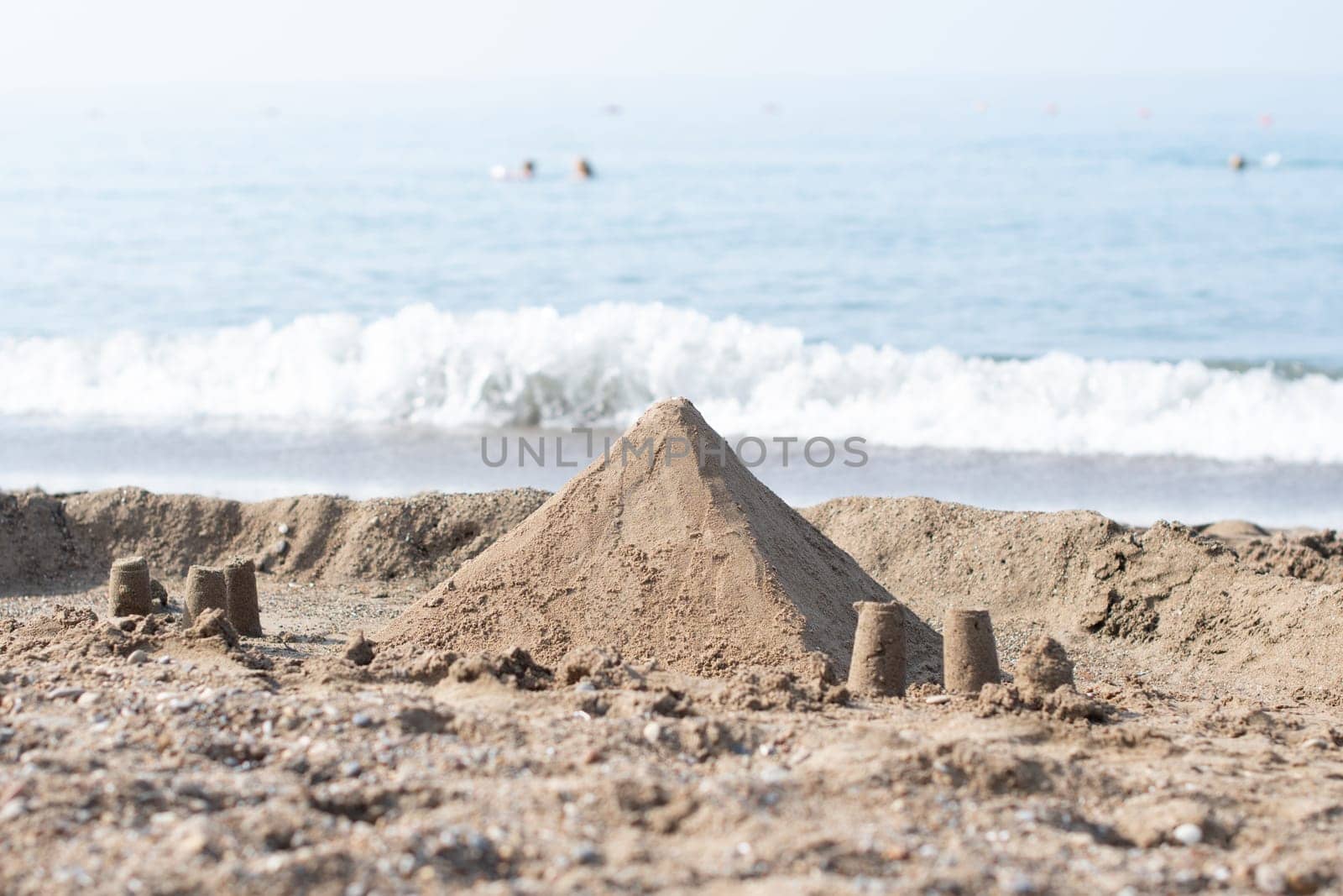 Sand pyramid on the beach with the sea in the background, summer vacation in a tropical country