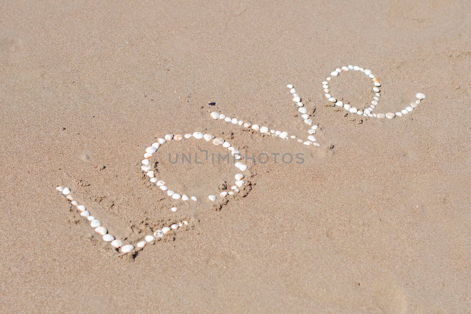 the inscription love on the wet sand of the sea beach in Turkey, lined with white shells, a love message, a declaration of love