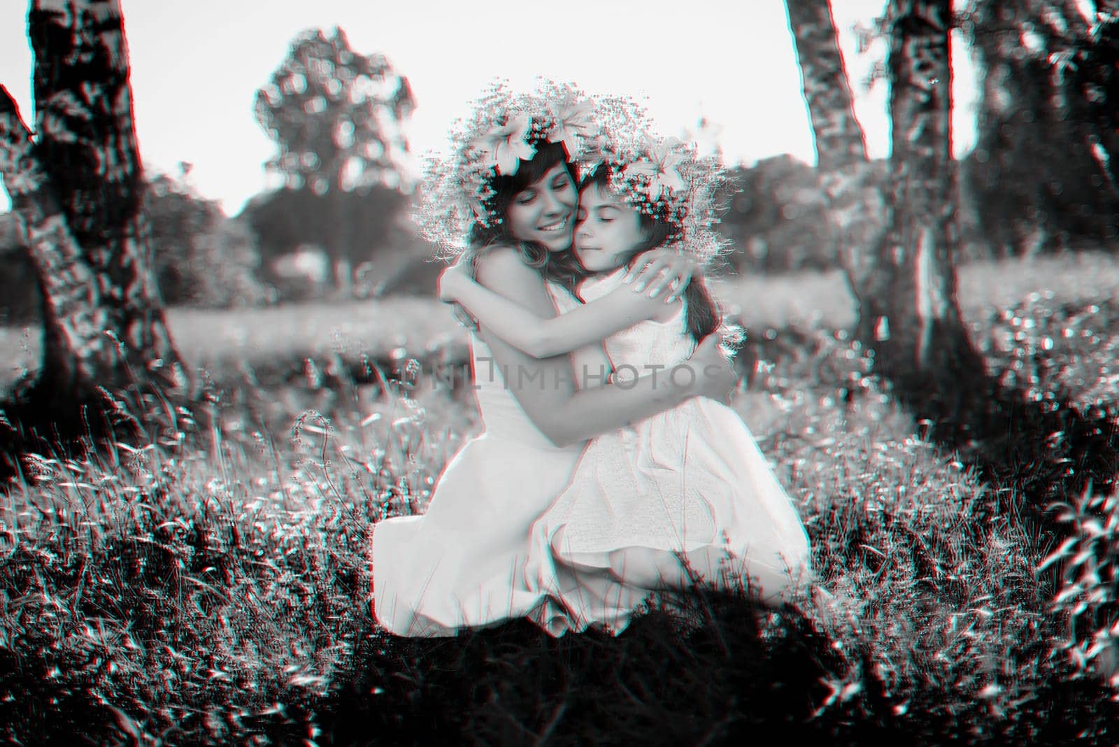 mom hugs her daughter sitting on the grass outdoors on a Sunny summer day. Black and white monochrome photography with 3D glitch effect