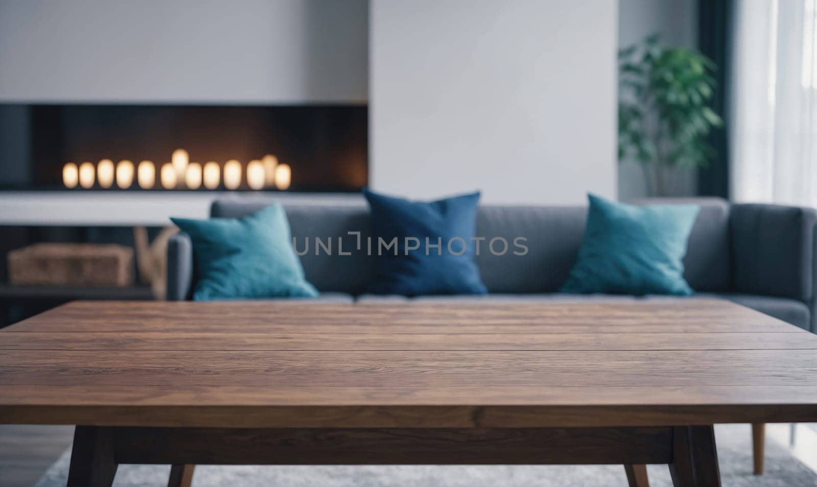 A wooden coffee table is in the foreground with a sofa with blue pillows and a fireplace in the background.