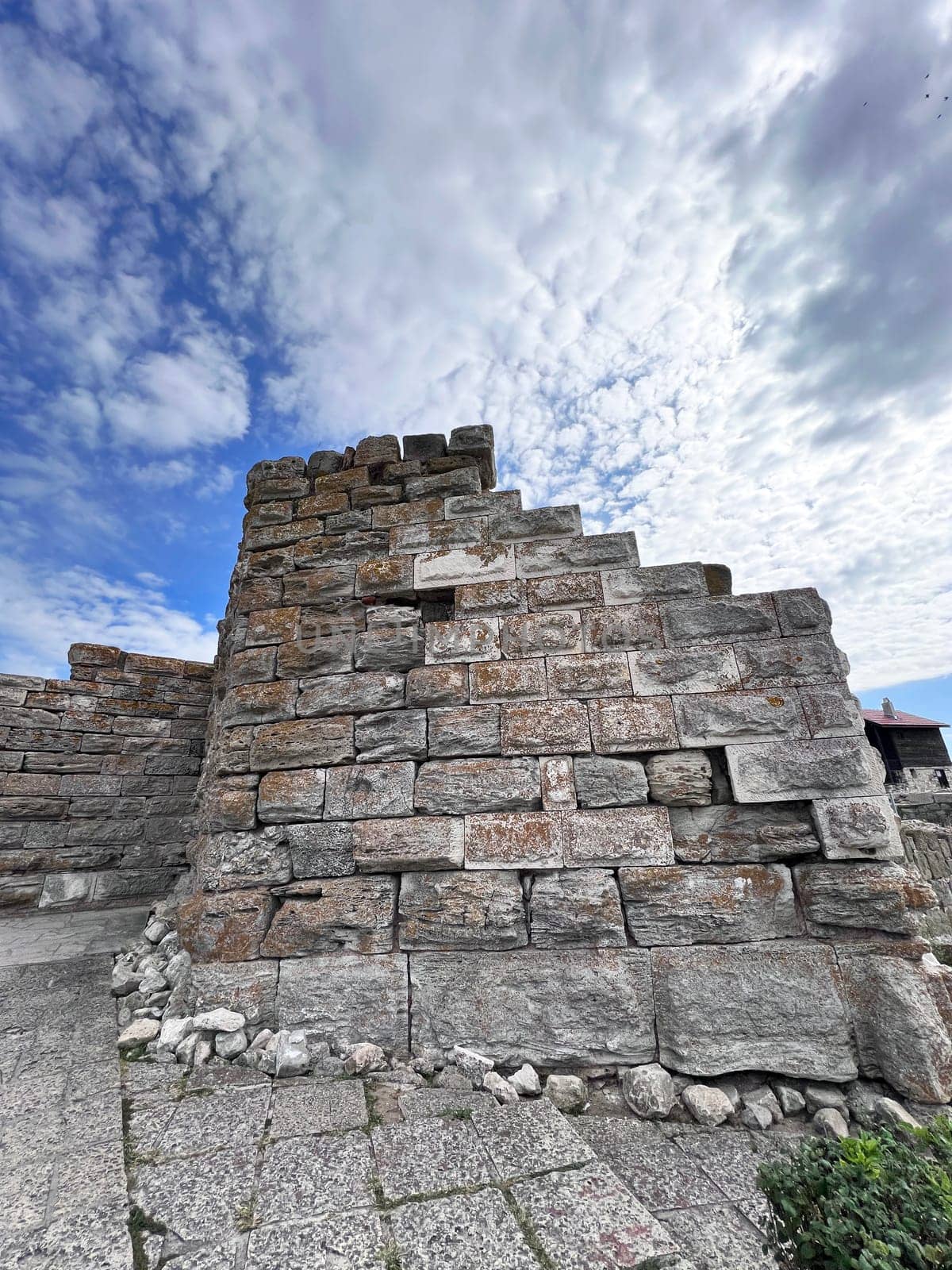 a adobe and stone wall with picturesque house. High quality photo