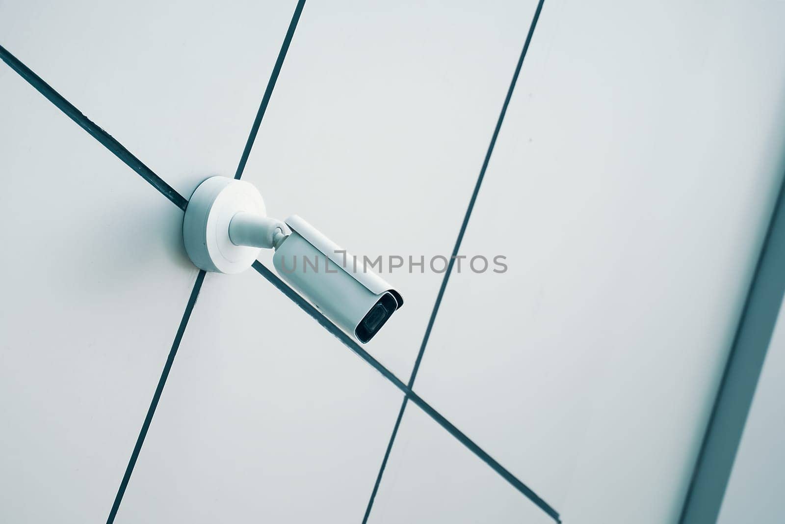 A sleek and modern security camera is securely mounted on a minimalist wall, ensuring safety and effective surveillance