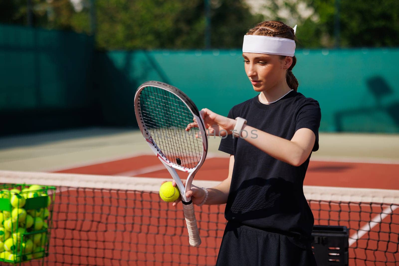girl tennis player adjusts the strings of a tennis racket close-up during a match, against the background of a court, tennis game