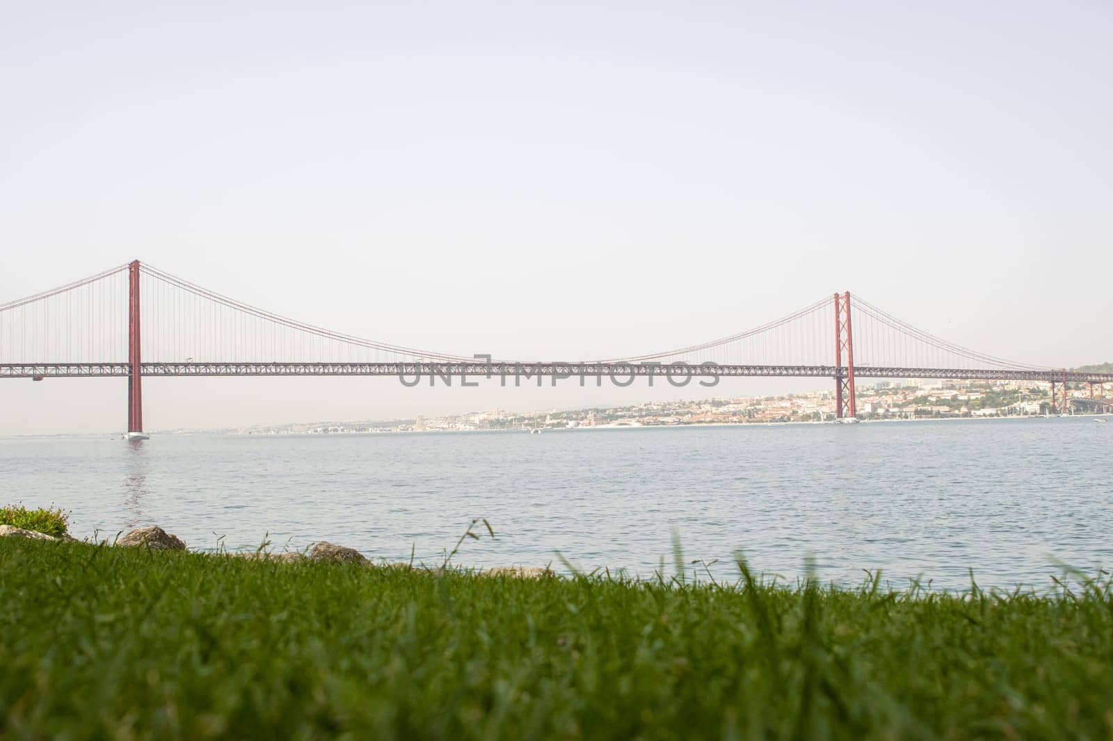 Bridge of 25 april - view of Lisboa Harbor with vessels and Port cranes, day