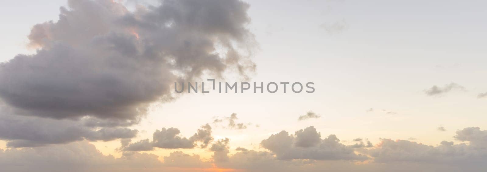 Panoramic beautiful clouds against the background of the sun.