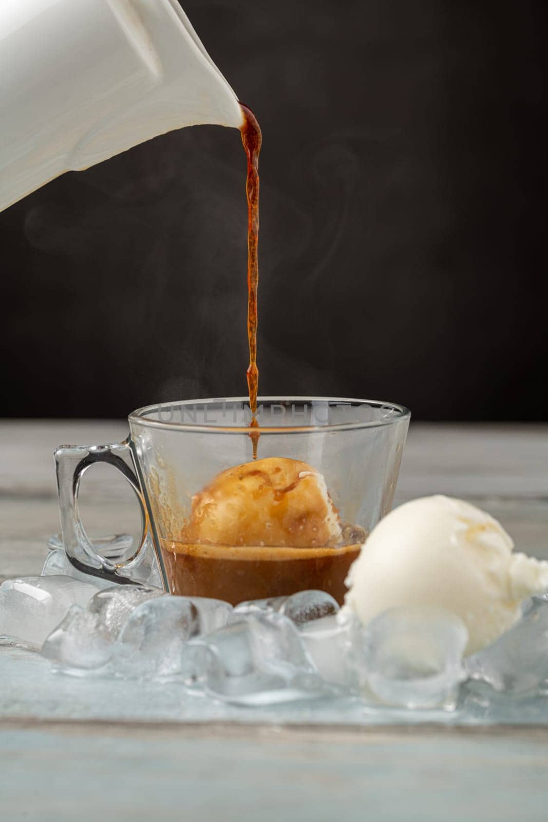 Affogato coffee with vanilla ice cream in a glass cup on wooden table by Sonat