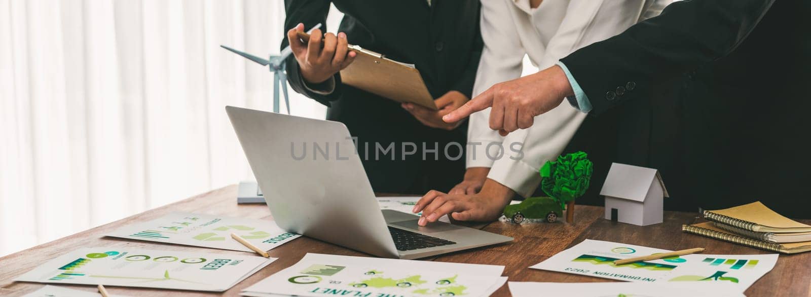 Eco business company meeting with group of business people using laptop to plan strategy and discuss marketing of eco-friendly and clean energy products. Green business company concept. Trailblazing