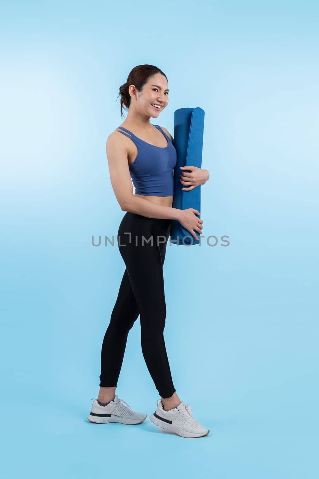 Young attractive asian woman portrait in sportswear with exercising mat. Healthy exercise and workout routine lifestyle concept. Studio shot isolated background. Vigorous