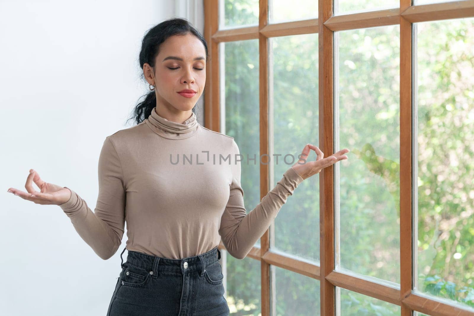 Young African American woman practice crucial mindful meditation at home living room for improving mental health strength and peaceful beautiful living