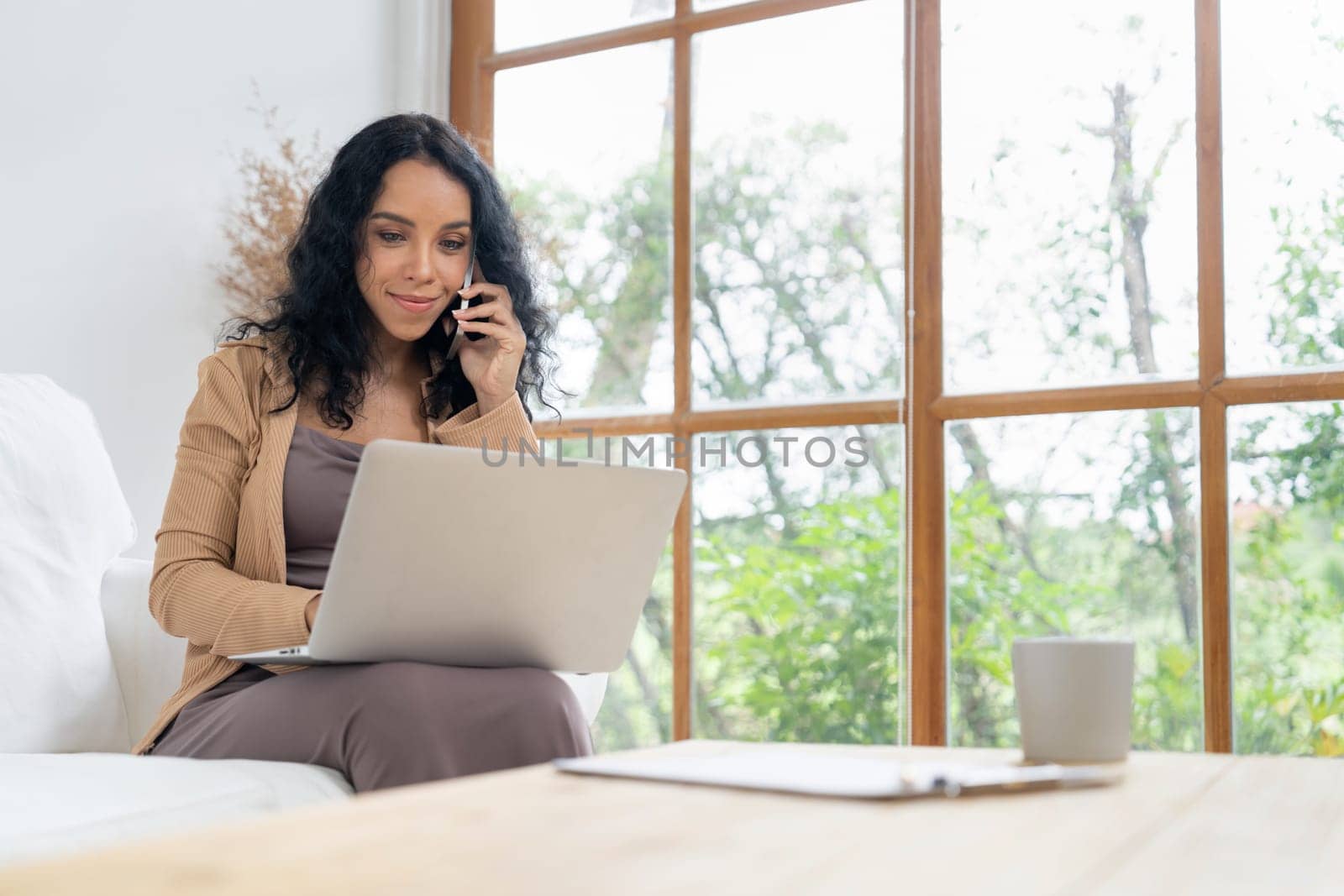 African-American woman using laptop computer for crucial work on internet. Secretary or online content writing working at home.