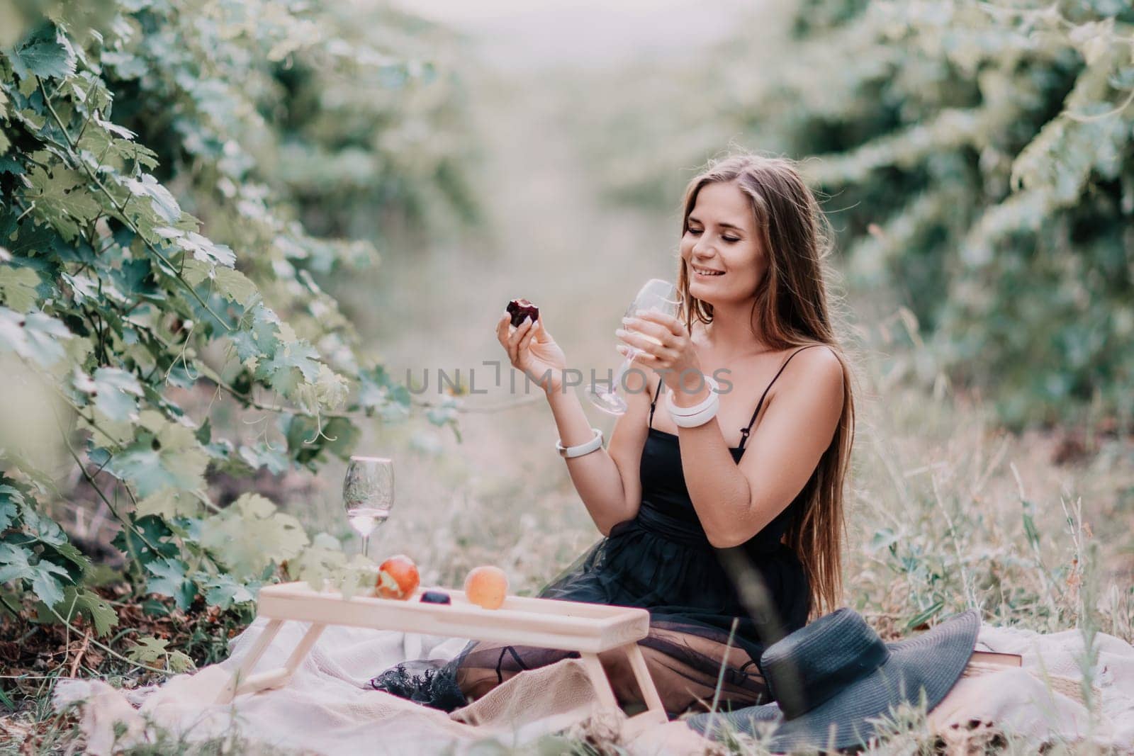 Picnic and wine tasting at sunset in the hills of Italy, Tuscany. Vineyards and open nature in the summer. Romantic dinner, fruit and wine.