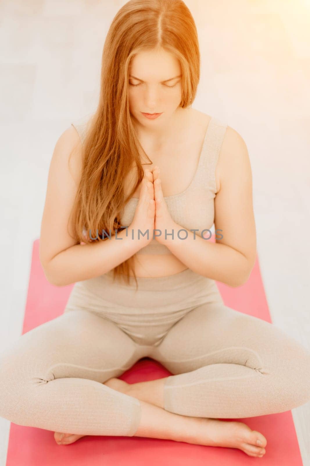 young sporty woman, fitness instructor in sportswear doing stretching and pilates on yoga mat in the studio with mirror. Female fitness yoga routine concept. Healthy lifestyle and harmony. by panophotograph