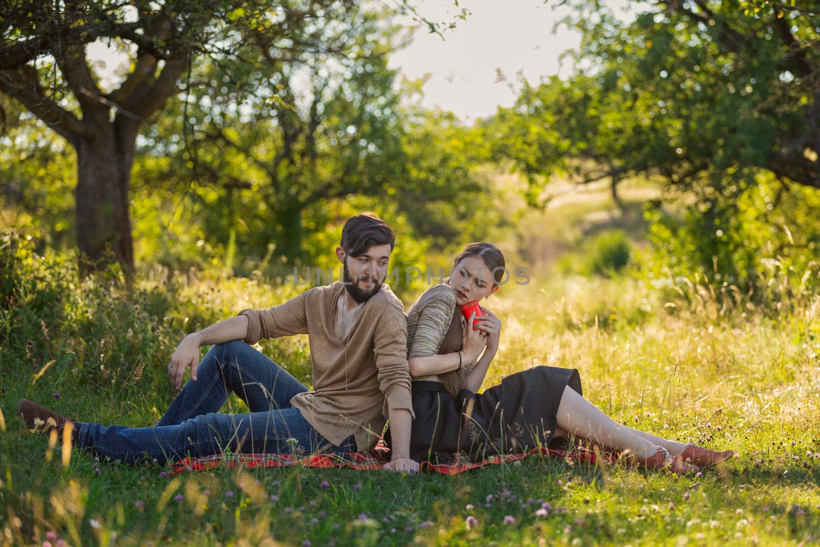 Young couple in nature, a girl with a phone is texting someone