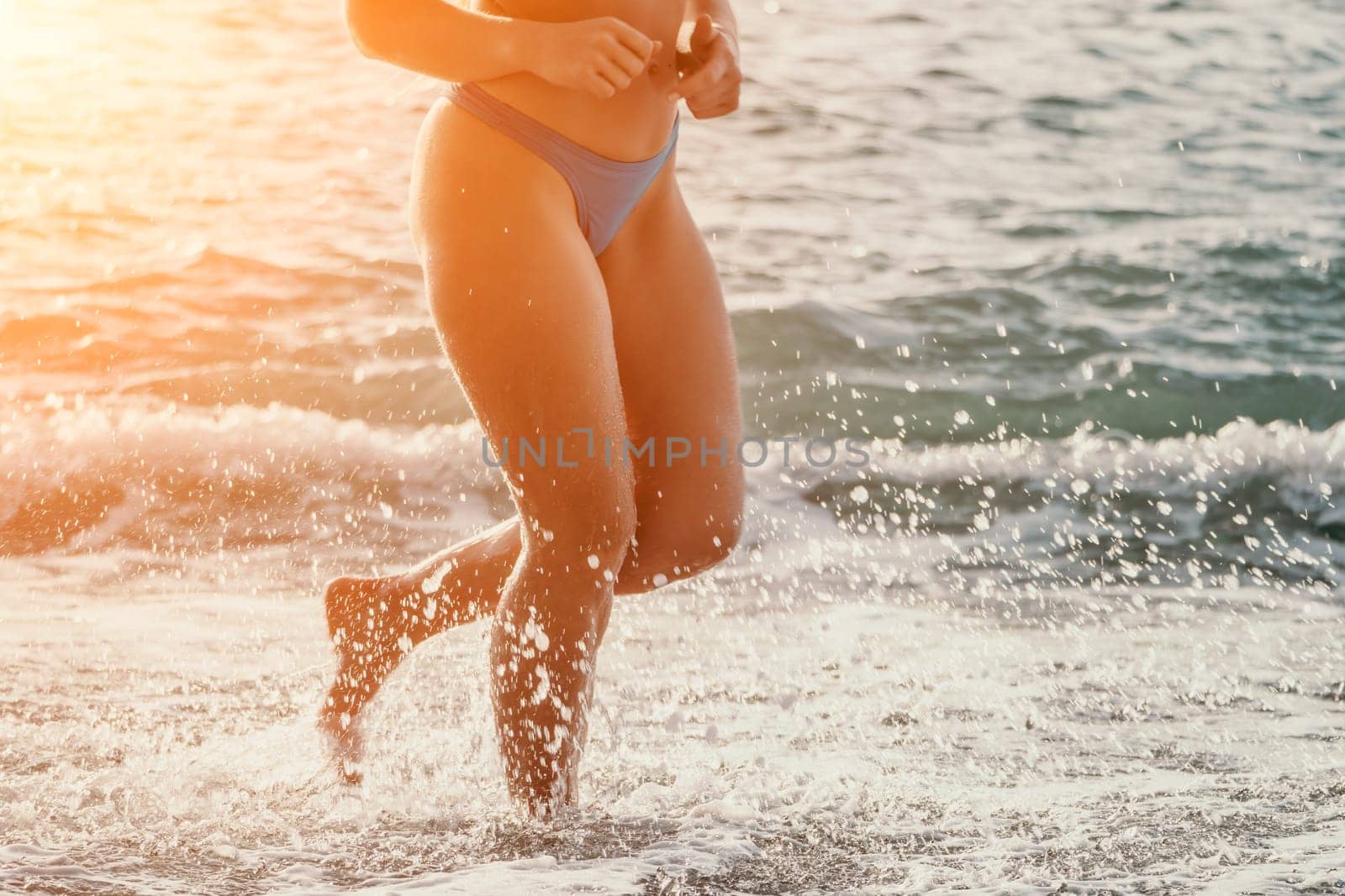 Running woman on a summer beach. A woman jogging on the beach at sunrise, with the soft light of the morning sun illuminating the sand and sea, evoking a sense of renewal, energy and health. by panophotograph