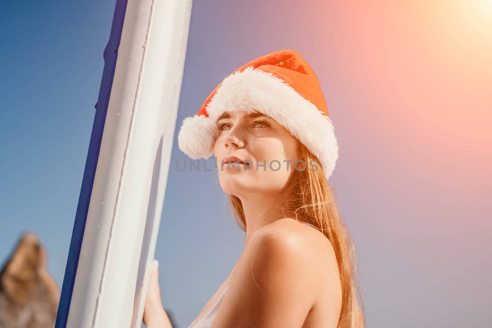 Close up shot of happy young caucasian woman looking at camera and smiling. Cute woman portrait in bikini posing on a volcanic rock high above the sea