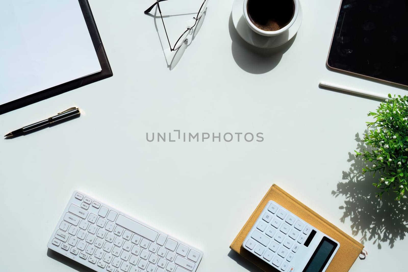 Top view above of white office desk table with keyboard computer, notebook and coffee cup with equipment other office supplies. business and finance concept. workplace, flat lay with blank copy space.