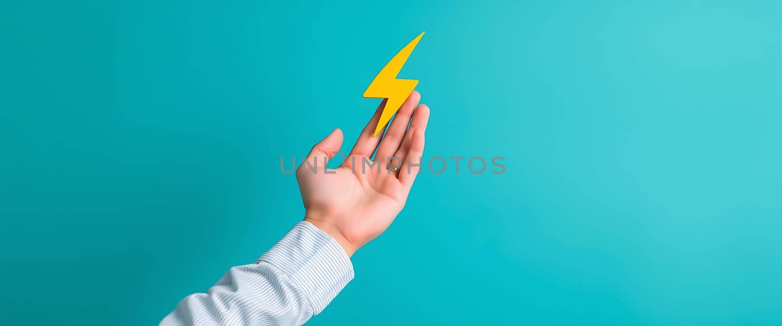 A hand extends towards a striking yellow lightning bolt placed against a bright blue background. The indoor environment highlights creativity and energy.