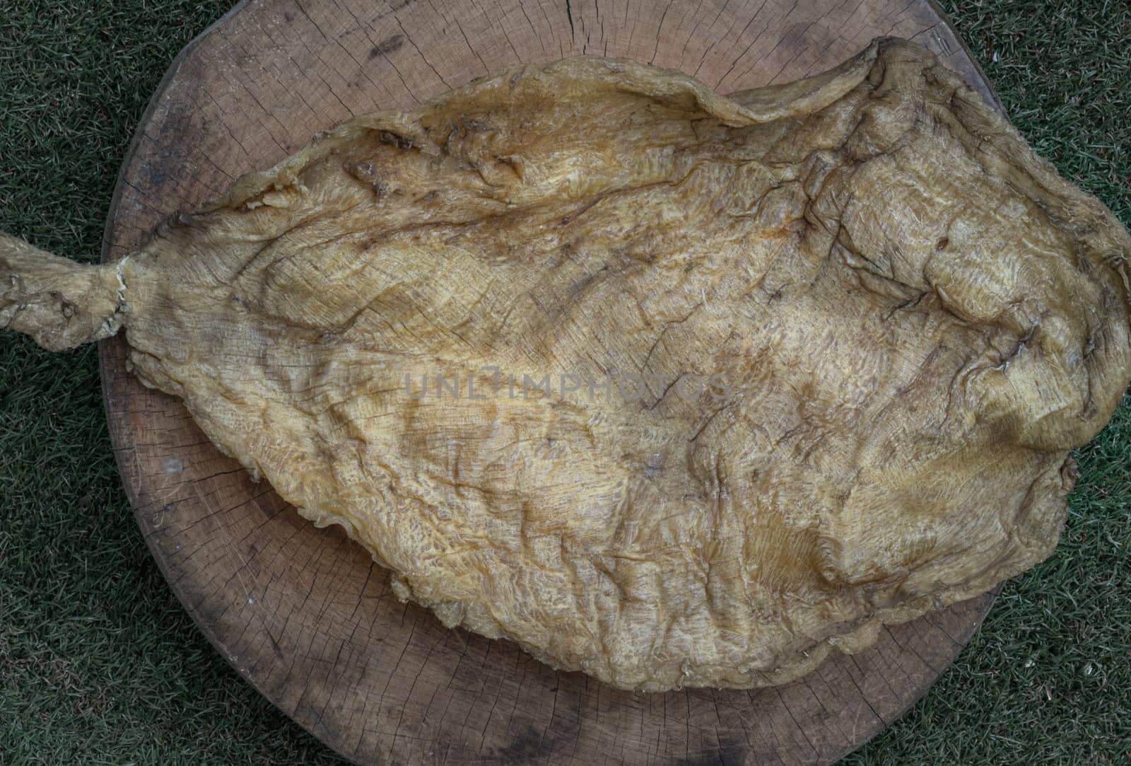 Detail of Fish Maw Soup or Dried Fish Stomach (Dried Fish Bladder) on Old wooden cutting board. Chinese dried food, Healthy eating lifestyle concept, Top view, Space for text, Selective focus.