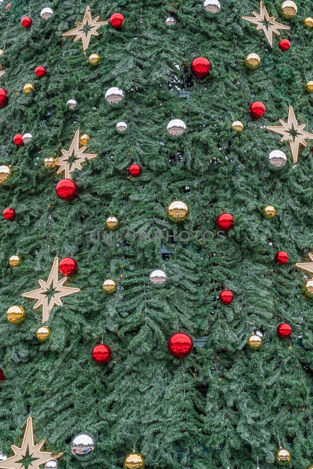 A beautifully adorned Christmas tree is covered in red, silver, and gold ornaments, alongside shining stars, creating a festive atmosphere perfect for the holiday season.