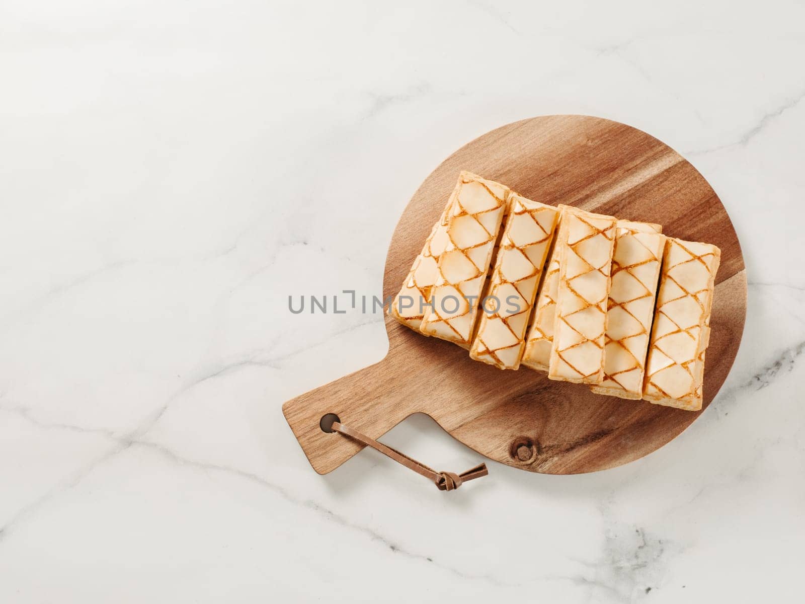Italian crispy sweet bakery Sfogliatine glassate over white marble table surface. Tasty breakfast with apricot glaze puff pastries. Top view. Copy space