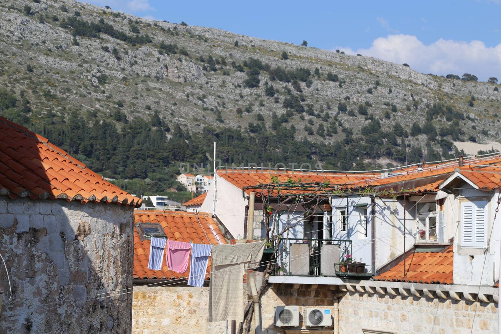Dubrovnik, Croatia, old town, tiled roof of a house ancient stone building with a triangular facade top view travel places, windows blue sky landscape architecture April 22, 2023. High quality photo