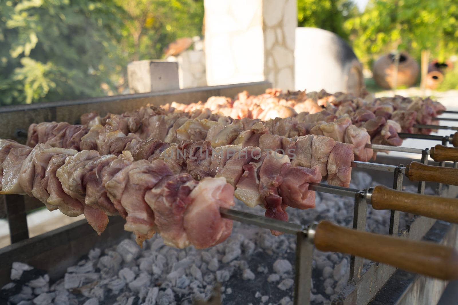 Shashlik being fried out-of-doors in a park on Cyprus island on summer sunny day close up shot