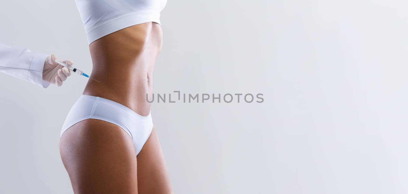 Beauty procedure. Afro woman having lipolysis treatment for waist at beauty salon, close up