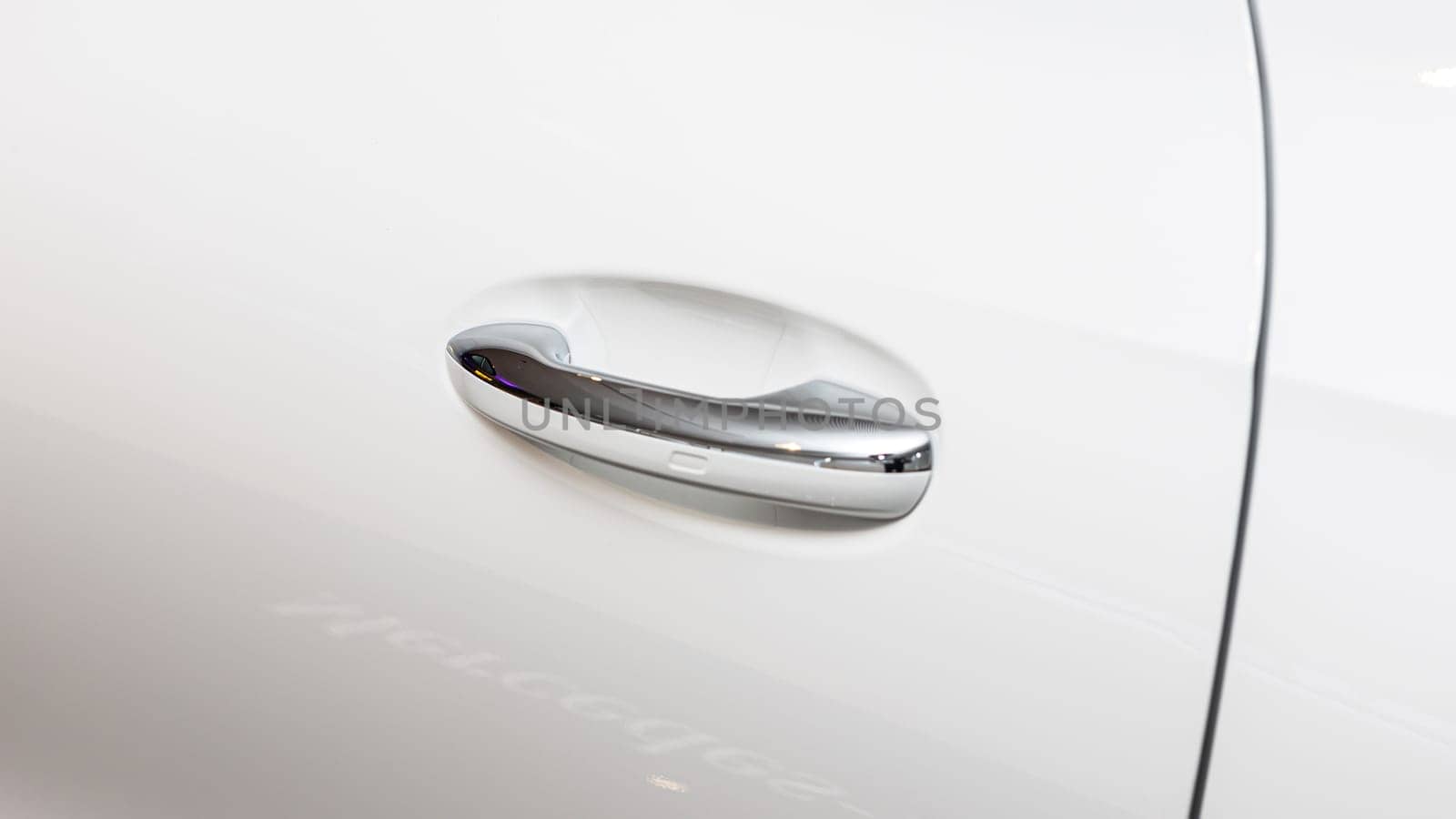 Chrome car door handle on a luxury vehicle, showcasing modern automotive design and high-end craftsmanship.