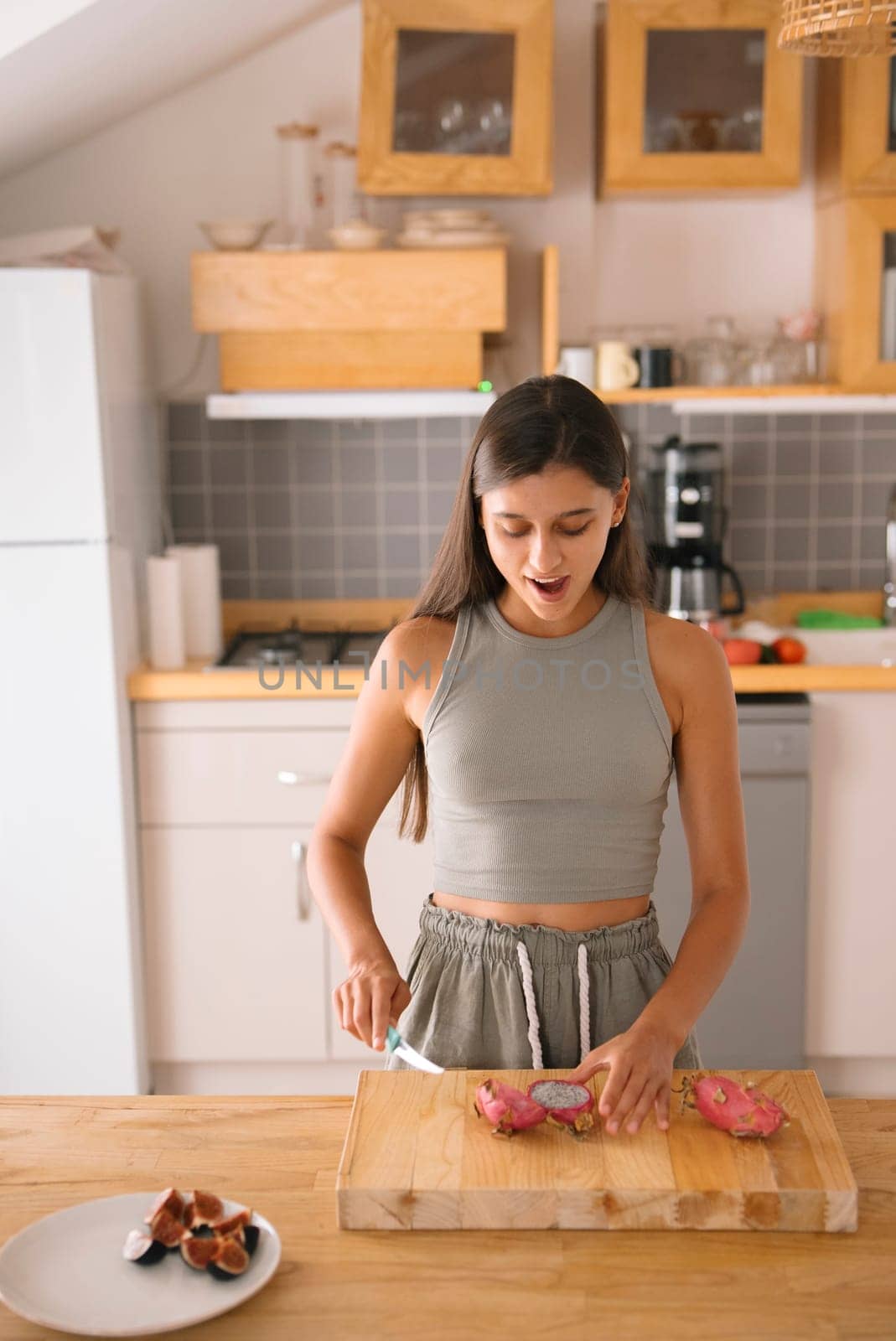 A woman skillfully and expertly slices a variety of colorful ingredients in her stylish and modern kitchen