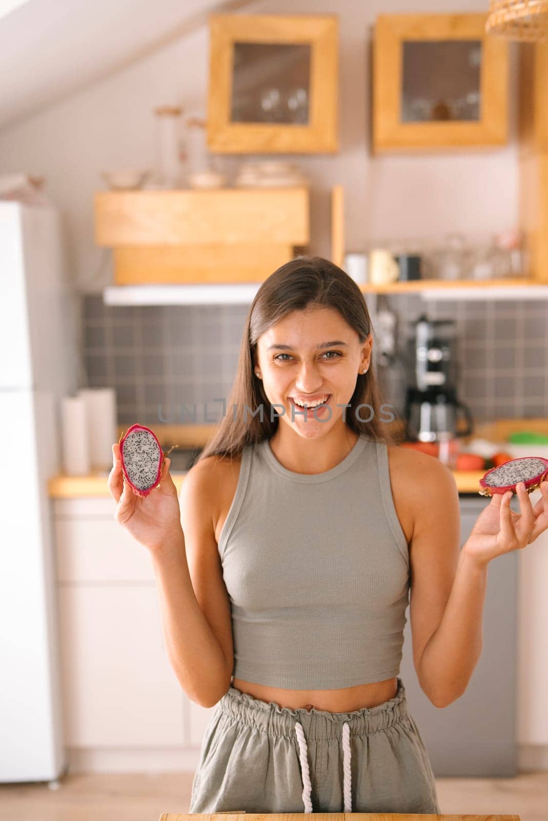 A joyful woman proudly showcases a variety of healthy snacks in a beautifully designed contemporary kitchen environment